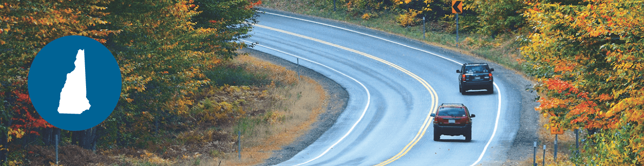 Two cars driving on a winding road in forest