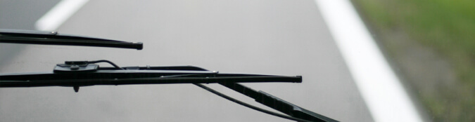 windshield wiper in front of view of a road