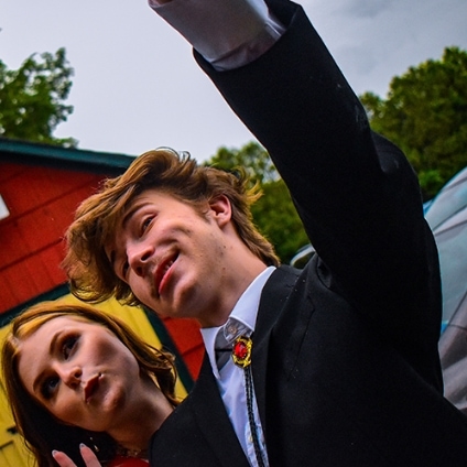 figure wearing a tuxedo in front of limo