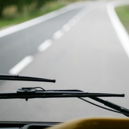 windshield wiper in front of view of a road