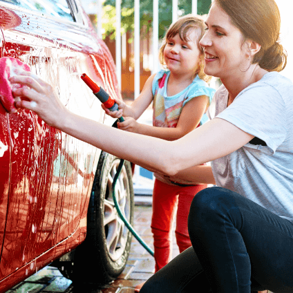 mother and daughter washing car